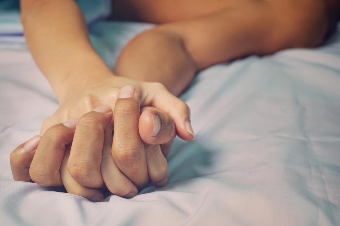man-and-woman-holding-hands-in-bed.jpg