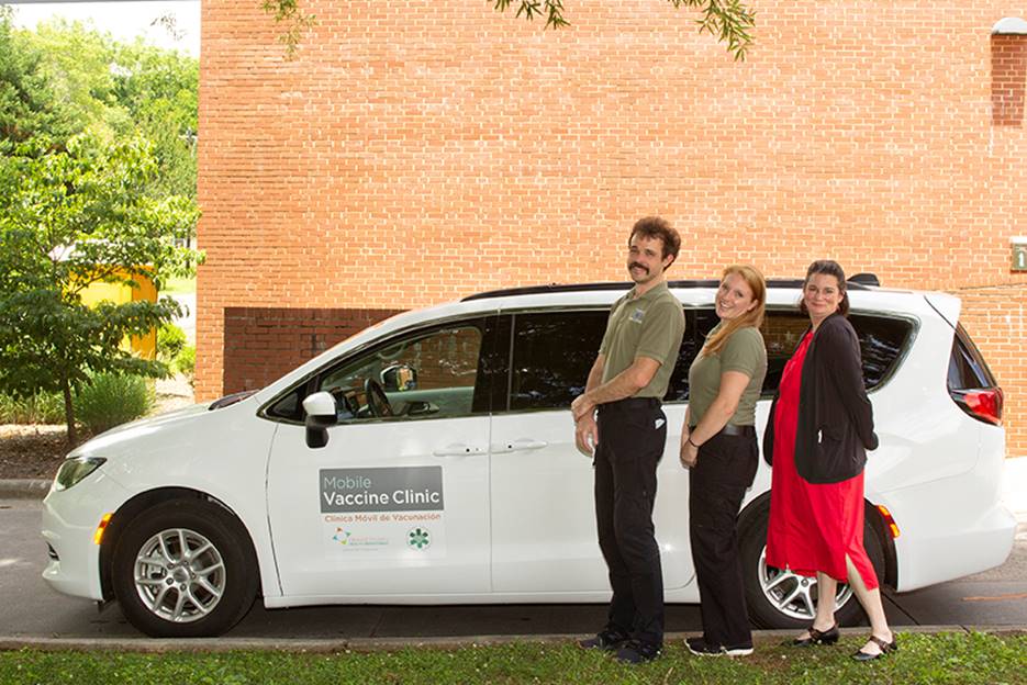 A group of people standing next to a car

Description automatically generated with medium confidence