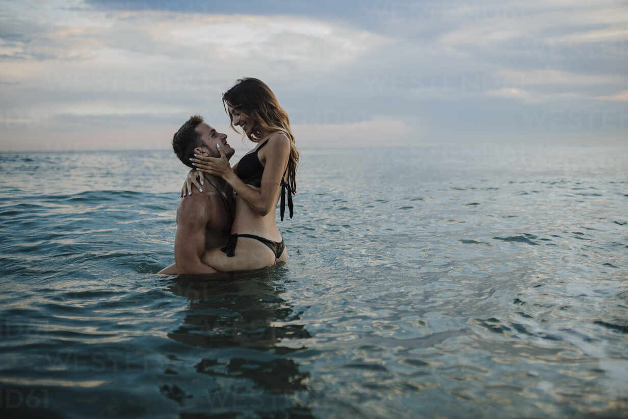young-couple-doing-romance-in-water-at-beach-during-sunset-GMLF00718.jpg