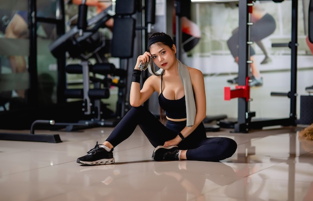portrait-young-sexy-woman-wearing-sportswear-smartwatch-sitting-floor-wipe-sweat-after-workout-gym_1150-47188.jpg