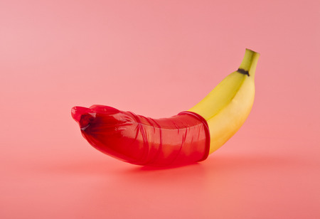 115086439-banana-with-a-red-condom-on-a-pink-background-safe-concept.jpg