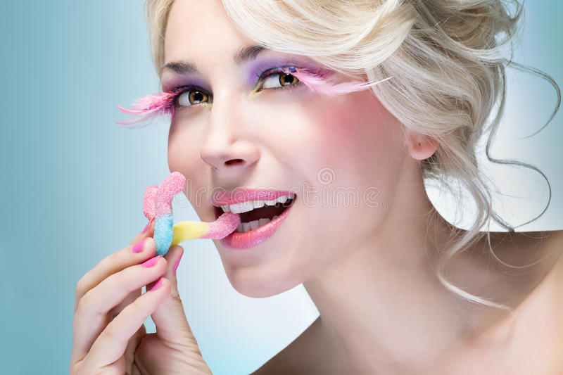 girl-eating-candy-bright-makeup-35887688.jpg
