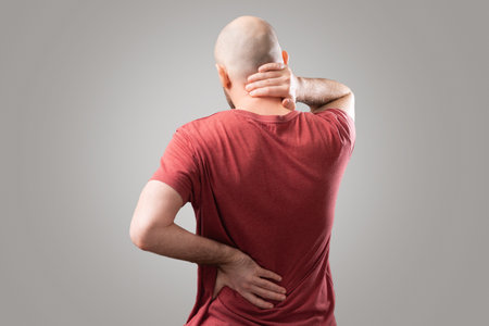 195228974-back-pain-the-man-holds-his-hands-to-the-lower-back-and-neck-osteochondrosis-the-concept-of-joint.jpg