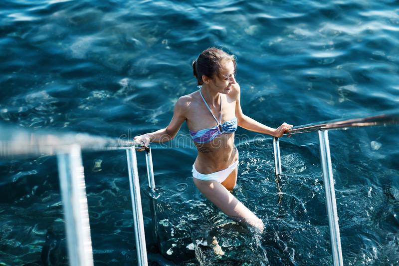 sexy-bikini-smiling-woman-coming-out-water-holding-onto-handrails-young-model-slim-weight-loss-body-sexy-bikini-142379545.jpg