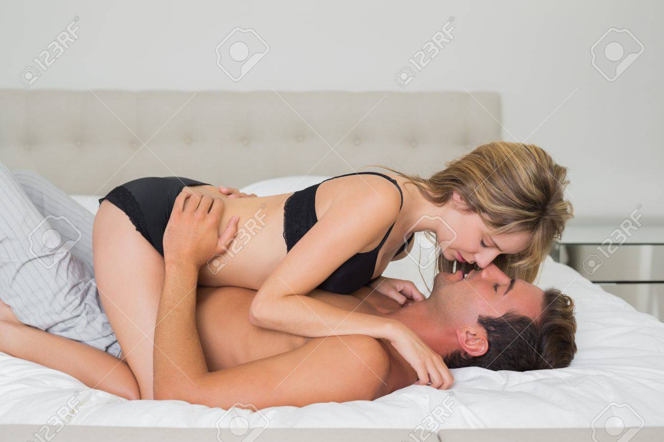 28044401-side-view-of-a-romantic-young-couple-in-underwear-in-bed-at-home.jpg