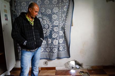 The father of Fares stands near where the shrapnel penetrated his home and decapitated his son.