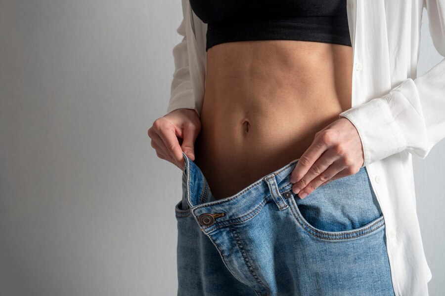 slender-woman-with-bare-stomach-shows-how-she-lost-weight-holding-her-jeans-with-her-hand-concept-diet-weight-loss-healthy-lifestyle_136344-928.jpg